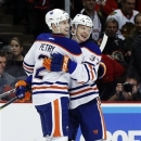 Edmonton Oilers defenseman Jeff Petry (2) celebrates with center Lennart Petrell, of Finland, after his goal during the first period of an NHL hockey game against the Chicago Blackhawks, Monday, Feb. 25, 2013, in Chicago. (AP Photo/Charles Rex Arbogast)