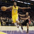 Los Angeles Lakers forward Earl Clark (6) saves a ball heading out of bounds as Toronto Raptors' Kyle Lowry defends during the first half of an NBA basketball game in Los Angeles Friday, March 8, 2013. (AP Photo/Reed Saxon)