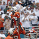 Miami offensive linesman Jon Feliciano (70) and Ladarius Gunter (37) celebrate during the second half of an NCAA football game against Florida, Saturday, Sept. 7, 2013, in Miami Gardens, Fla. Miami won 21-16. (AP Photo/Alan Diaz)