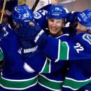 Vancouver Canucks' Henrik Sedin, of Sweden; Alex Burrows; and Daniel Sedin, of Sweden, from left, celebrate Burrows' goal against the St. Louis Blues during the third period of an NHL hockey game in Vancouver, British Columbia, on Thursday, March 1, 2012. (AP Photo/The Canadian Press, Darryl Dyck)