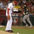 Los Angeles Angels relief pitcher Sean Burnett looks down as Oakland Athletics' Yoenis Cespedes rounds the bases after a home run during the seventh inning of a baseball game in Anaheim, Calif., Thursday, April 11, 2013. (AP Photo/Chris Carlson)