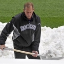 Colorado Rockies owner Dick Monfort shovels snow from the field before the start of a scheduled baseball double-header between the New York Mets and the Colorado Rockies on Tuesday, April 16, 2013, in Denver. (AP Photo/Jack Dempsey)