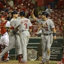 Matt Holliday, second from left, is congratulated at home plate after his 10th inning grand slam in a game where the St. Louis Cardinals beat the Cincinnati Reds 11-4 in 10 innings, Sunday, June 9, 2013, at Great American Ball Park in Cincinnati.  (AP Photo/ Michael E. Keating)
