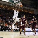 Miami's Reggie Johnson (42) dunks a ball as Virginia Tech's Joey van Zegeren (2) and C.J. Barksdale (42) watch during the second half of an NCAA college basketball game in Coral Gables, Fla., Wednesday, Feb. 27, 2013. Miami won 76-58. (AP Photo/J Pat Carter)