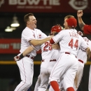 Cincinnati Reds' Jay Bruce, left, and Mike Leake, right, celebrate with Ryan Hanigan, middle, after Hanigan hit an RBI game-winning double off Los Angeles Dodgers relief pitcher Ronald Belisario in the ninth inning during a baseball game, Sunday, Sept. 8, 2013, in Cincinnati. The Reds won 3-2. (AP Photo/David Kohl)