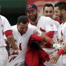 St. Louis Cardinals' Rafael Furcal, center, is congratulated by teammates after his game-wining single in the ninth inning of a baseball game against the Miami Marlins, Sunday, July 8, 2012, in St. Louis. The Cardinals won 5-4. (AP Photo/Tom Gannam)