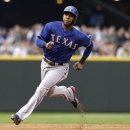 Texas Rangers' Elvis Andrus comes around third as he heads home to score against the Seattle Mariners in the second inning of a baseball game on Saturday, May 25, 2013, in Seattle. (AP Photo/Elaine Thompson)