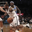 Brooklyn Nets' C.J. Watson, foreground, drives past Denver Nuggets' Ty Lawson during the first half of an NBA basketball game on Wednesday, Feb. 13, 2013, at Barclays Center in New York. (AP Photo/Mary Altaffer)