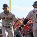 San Francisco Giants' Angel Pagan is congratulated by Marco Scutaro (19) after Pagan hit a solo home run in the first inning of Game 4 of the National League division baseball series against the Cincinnati Reds, Wednesday, Oct. 10, 2012, in Cincinnati. (AP Photo/Al Behrman)