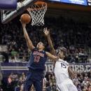 Arizona's Nick Johnson (13) puts up a shot as Washington's Scott Suggs (15) defends in the second half of an NCAA college basketball game, Thursday, Jan. 31, 2013, in Seattle. Arizona won 57-53. (AP Photo/Ted S. Warren)