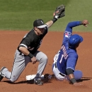 Texas Rangers' Elvis Andrus, right, is tagged out by Chicago White Sox shortstop Steve Tolleson, left,  as he tried to steal second during an exhibition spring training baseball game Tuesday, Feb. 26, 2013, in Surprise, Ariz. (AP Photo/Charlie Riedel)