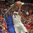 Florida's Patric Young (4) blocks the shot of Arizona's Kevin Parrom (3) during the first half of an NCAA college basketball game  at McKale Center in Tucson, Ariz.,Saturday, Dec. 15, 2012. (AP Photo/John Miller)