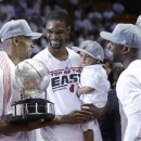 Miami Heat's Ray Allen, left, holds the NBA Eastern Conference trophy as Chris Bosh hold his son Jackson and Dwyane Wade and LeBron James smile, Monday, June 3, 2013, in Miami. The Heat defeated the Indiana Pacers 99-76 to advance to the NBA Finals against the San Antonio Spurs. (AP Photo/Lynne Sladky)
