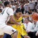 Michigan's Trey Burke, right, is fouled by Michigan State's Gary Harris (14) as he drives during the first half of an NCAA college basketball game, Tuesday, Feb. 12, 2013, in East Lansing, Mich. (AP Photo/Al Goldis)