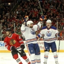 Edmonton Oilers' Mike Brown, center, celebrates his goal with teammate Lennart Petrell (37), from Finland, as Chicago Blackhawks center Jamal Mayers skates away during the first period of an NHL hockey game Sunday, March 10, 2013 in Chicago. (AP Photo/Charles Rex Arbogast)