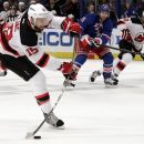 New Jersey Devils' Travis Zajac, left, scores against the New York Rangers during the first period of Game 5 of an NHL hockey Stanley Cup Eastern Conference final playoff series, Wednesday, May 23, 2012, in New York. Rangers' Mike Rupp, center, and Devils' Dainius Zubrus, of Lithuania, right, watche the shot. (AP Photo/Frank Franklin II)