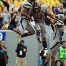 West Virginia players, from left, Tavon Austin, Andrew Buie and Stedman Bailey celebrate Austin's touchdown during an NCAA college football game against the University of Maryland in Morgantown, W.Va., Saturday, Sept. 22, 2012. (AP Photo/Christopher Jackson)