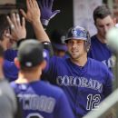 Colorado Rockies' Andrew Brown celebrates with teammates in the dugout after hitting a solo home run against the Chicago Cubs in the sixth inning of a baseball game in Chicago, Saturday, Aug. 25, 2012. Colorado won 4-3. (AP Photo/Paul Beaty)