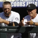 Colorado Rockies right fielder Michael Cuddyer, left, tallks with bench coach Tom Runnells as the Rockies bat against the New York Mets in the first inning of a baseball game in Denver on Thursday, June 27, 2013. Cuddyer singled in the second inning to push his hitting streak to 24 games, a new personal record as well as a new team record for the Rockies. (AP Photo/David Zalubowski)