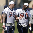 FILE - In this April 28, 2015, file photo, Denver Broncos defensive ends Derek Wolfe, left, and Antonio Smith chat as they leave the field after the NFL football team's voluntary veterans minicamp in Englewood, Colo. Smith is under investigation in Texas over criminal allegations the local sheriff described as 