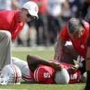 Ohio State trainers tend to quarterback Braxton Miller after he was injured during the first quarter of an NCAA college football game against San Diego State on Saturday, Sept. 7, 2013, in Columbus, Ohio. (AP Photo/Jay LaPrete)