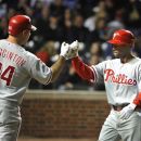 Philadelphia Phillies' Ty Wigginton, left, high-fives teammate Jimmy Rollins after Rollins and Roy Halladay scored on a throwing error by Chicago Cubs relief pitcher Blake Parker during the eighth inning of a baseball gameon Thursday, May 17, 2012 in Chicago. (AP Photo/Brian Kersey)
