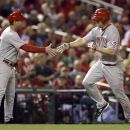 Cincinnati Reds' Scott Rolen, right, is congratulated by third base coach Mark Berry while rounding the bases after hitting a solo home run during the fourth inning of a baseball game against the St. Louis Cardinals, Tuesday, Oct. 2, 2012, in St. Louis. (AP Photo/Jeff Roberson)