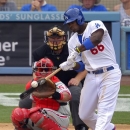Los Angeles Dodgers' Yasiel Puig, right, hits a single as Philadelphia Phillies catcher Carlos Ruiz, left, and home plate umpire Bill Miller look on during the fourth inning of their baseball game, Sunday, June 30, 2013, in Los Angeles. (AP Photo/Mark J. Terrill)