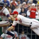 Atlanta Braves' Martin Prado (14) is run down on his way to the plate by Washington Nationals third baseman Ryan Zimmerman (11) during the eighth inning of the first baseball game of a doubleheader, Saturday, July 21, 2012, in Washington. The Braves won 4-0. (AP Photo/Carolyn Kaster)
