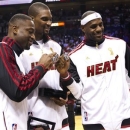 From left, Miami Heat's Dwyane Wade, Chris Bosh and LeBron James pose with their 2012 NBA Finals championship rings during a ceremony before a basketball game against the Boston Celtics, Tuesday, Oct. 30, 2012, in Miami. (AP Photo/J Pat Carter)