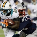 New England Patriots defensive end Chandler Jones, right, tackles Miami Dolphins running back Lamar Miller (26) during the first quarter of an NFL football game in Foxborough, Mass., Sunday, Dec. 30, 2012. (AP Photo/Elise Amendola)