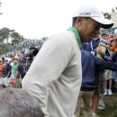 Tiger Woods reacts after colliding with a photographer while walking off the 18th green at the conclusion of his third round of the 2012 U.S. Open golf tournament on the Lake Course at the Olympic Club in San Francisco, California June 16, 2012. REUTERS/Danny Moloshok
