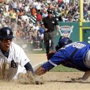 Detroit Tigers' Quentin Berry, left, scores the winning run on a Alex Avilla single as Toronto Blue Jays' catcher Yorvit Torrealba, right, reaches to make a tag in the 11th inning of a baseball game on Thursday, Aug. 23, 2012, in Detroit. (AP Photo/Paul Sancya)