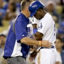 Los Angeles Dodgers' Dee Gordon reacts after hurting his hand after sliding into third against the Cincinnati Reds during the eighth inning of a baseball game in Los Angeles, Wednesday, July 4, 2012. (AP Photo/Chris Carlson)