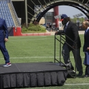 Defensive lineman Malcom Brown, second from left, the New England Patriots first round draft pick, takes the stage as Patriots owner Robert Kraft prepares to introduce Brown during a media availability at the NFL football team's facility Wednesday, May 27, 2015, in Foxborough, Mass. Patriots president Jonathan Kraft follows Brown, who played his college career at Texas. (AP Photo/Stephan Savoia)