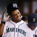 Seattle Mariners' Carlos Peguero, left, is congratulated by Jesus Montero after Peguero's home run against the Los Angeles Angels in the third inning of a baseball game, Thursday, April 25, 2013, in Seattle. (AP Photo/Elaine Thompson)