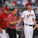 Los Angeles Angels starting pitcher Jered Weaver, right, is looked over by a trainer after an injury during the first inning of a baseball game against the New York Yankees in Anaheim, Calif., Monday, May 28, 2012. Weaver left his start against the Yankees in the first inning Monday night after apparently injuring his back while pitching. (AP Photo/Chris Carlson)
