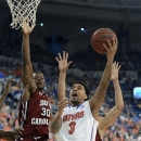 Florida guard Mike Rosario (3) goes to the basket to score against South Carolina's forward Lakeem Jackson (30) during the first half of an NCAA college basketball game in Gainesville, Fla., Wednesday, Jan. 30, 2013.  (AP Photo/Phil Sandlin)