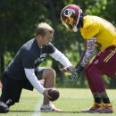 Washington Redskins offensive coordinator Sean McVay, left, works with quarterback Robert Griffin III during an NFL football organized team activity at Redskins Park, on Tuesday, May 26, 2015, in Ashburn, Va. (AP Photo/Evan Vucci)