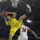 Michigan forward Mitch McGary (4) comes down with the rebound as Louisville guard/forward Wayne Blackshear (20) looks on during the first half of the NCAA Final Four tournament college basketball championship game Monday, April 8, 2013, in Atlanta. (AP Photo/David J. Phillip)