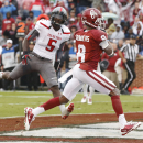 Oklahoma wide receiver Jalen Saunders (8) grabs a touchdown pass in front of Texas Tech defensive back Tre' Porter (5) during the second quarter of an NCAA college football game in Norman, Okla., Saturday, Oct. 26, 2013. (AP Photo/Sue Ogrocki)