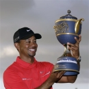 Tiger Woods holds the Gene Sarazen Cup for winning the Cadillac Championship golf tournament on Sunday, March 10, 2013, in Doral, Fla. (AP Photo/Wilfredo Lee)