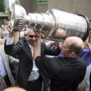 Chicago Blackhawks NHL hockey president and CEO John McDonough, center facing, hoists the Stanley Cup Trophy outside a Chicago steakhouse, Tuesday, June 25, 2013. McDonough was joined by Blackhawks owner Rocky Wirtz at the restaurant. (AP Photo/Scott Eisen)
