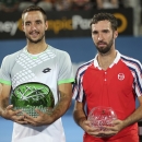 Viktor Troicki of Serbia left, and Mikhail Kukushkin of Kazakhstan pose with their winners' trophies for photographers after their men's final at the Sydney International Tennis tournament in Sydney, Australia, Saturday, Jan. 17, 2015. Troicki won the match. (AP Photo/Rob Griffith)