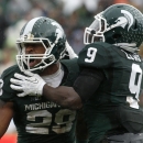 Michigan State's Denicos Allen, left, and Isaiah Lewis celebrate a stop by Allen against Michigan during the second quarter of an NCAA college football game, Saturday, Nov. 2, 2013, in East Lansing, Mich. (AP Photo/Al Goldis)