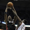 Miami Heat's Chris Bosh left, shoots over Milwaukee Bucks' Ekpe Udoh during the first half of an NBA basketball game on Saturday, Dec. 29, 2012, in Milwaukee. (AP Photo/Jim Prisching)