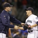 Seattle Mariners manager Eric Wedge, left, shakes hands with closing pitcher Danny Farquhar after the team beat the Kansas City Royals in a baseball game Tuesday, Sept. 24, 2013, in Seattle. The Mariner won 4-0. (AP Photo/Elaine Thompson)
