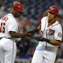 Washington Nationals' Ian Desmond, right, receives congratulations from his third base coach Bo Porter after hitting a two-run home run in the first inning of their baseball game against the Chicago Cubs at Nationals Park, Tuesday, Sept. 4, 2012, in Washington. (AP Photo/Richard Lipski)