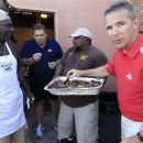 Michigan head football coach Brady Hoke, second from left, and Ohio State head football coach Urban Meyer, right, sample ribs from Gerald Wright, left, and Derrick McCray at the eighth annual Sound Mind, Sound Body Football Academy at the Southfield High School in Southfield, Mich., Wednesday, June 13, 2012. Meyer and Hoke were two of a handful of college coaches who were on hand at the camp, which draws kids from all over the country. (AP Photo/Carlos Osorio)