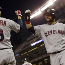Cleveland Indians' Nick Swisher, right, scores on an RBI-triple hit by Jason Kipnis in the first inning of a baseball game against the Minnesota Twins, Friday, Sept. 27, 2013, in Minneapolis. (AP Photo/Jim Mone)